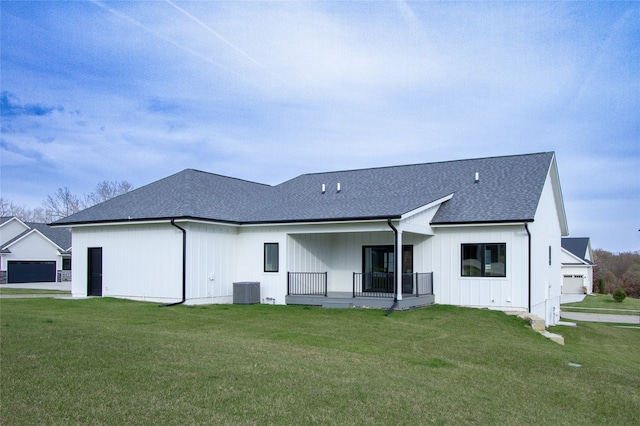 back of house with a porch, a yard, and a garage