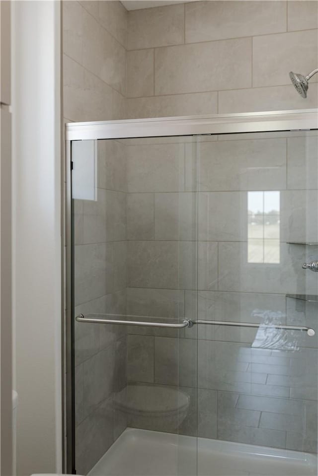 bathroom featuring a shower with door