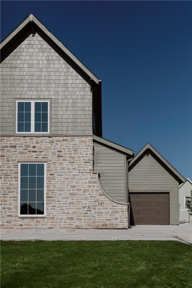 view of side of property featuring a garage and a yard