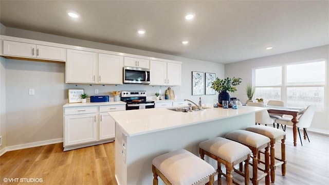 kitchen with sink, white cabinets, an island with sink, and appliances with stainless steel finishes