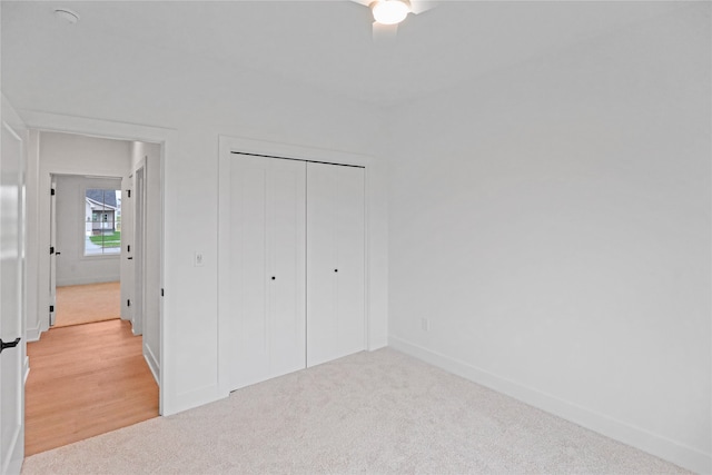 unfurnished bedroom featuring a closet and light colored carpet