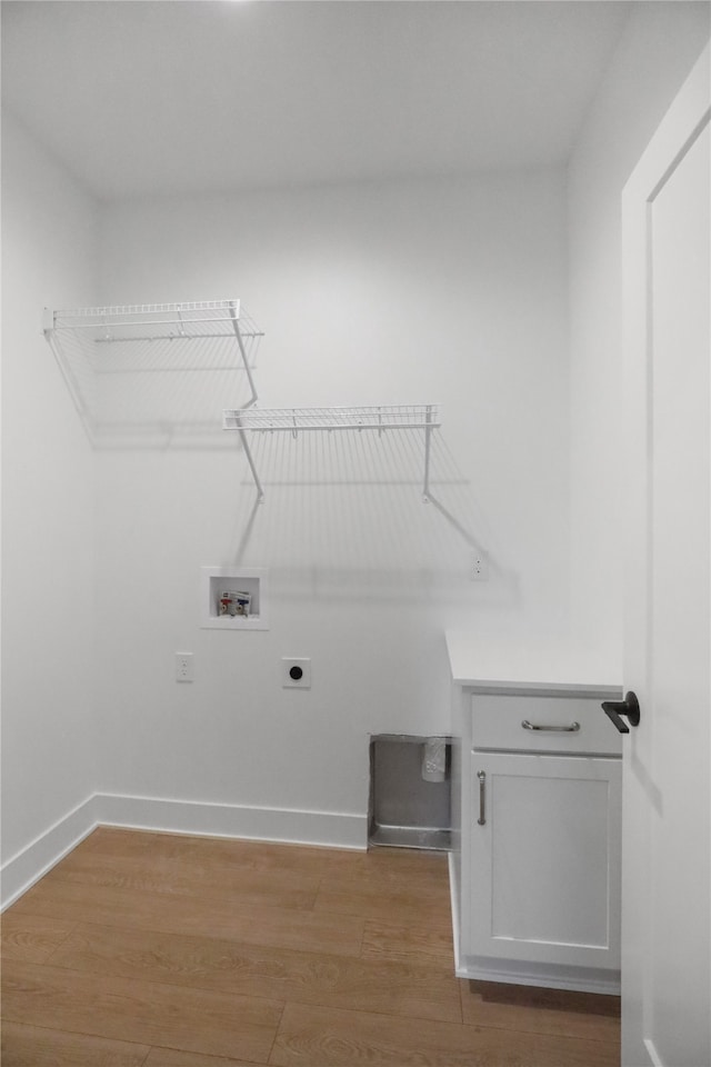 laundry room featuring electric dryer hookup, cabinets, hookup for a washing machine, and light hardwood / wood-style floors