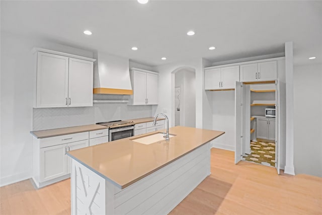 kitchen with sink, white cabinetry, an island with sink, and appliances with stainless steel finishes