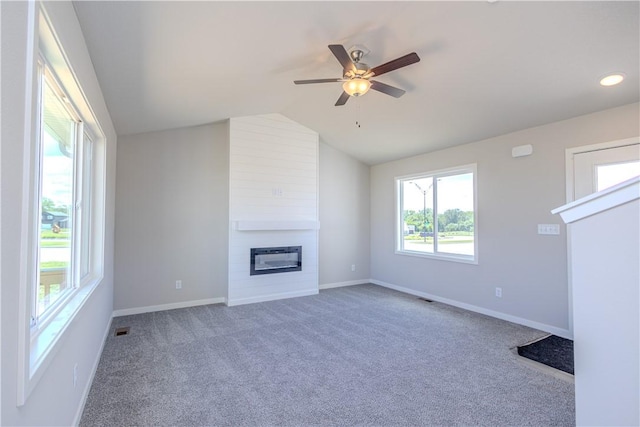 unfurnished living room featuring ceiling fan, a large fireplace, carpet floors, and lofted ceiling