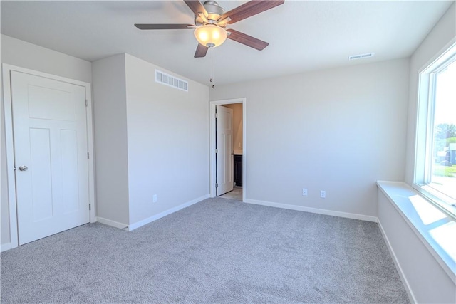 unfurnished bedroom featuring light colored carpet and ceiling fan