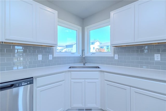 kitchen with dishwasher, decorative backsplash, white cabinetry, and sink