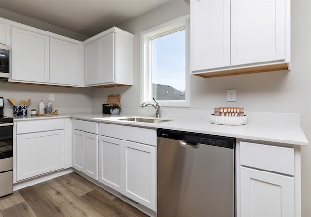 kitchen featuring appliances with stainless steel finishes, dark hardwood / wood-style floors, sink, and white cabinetry