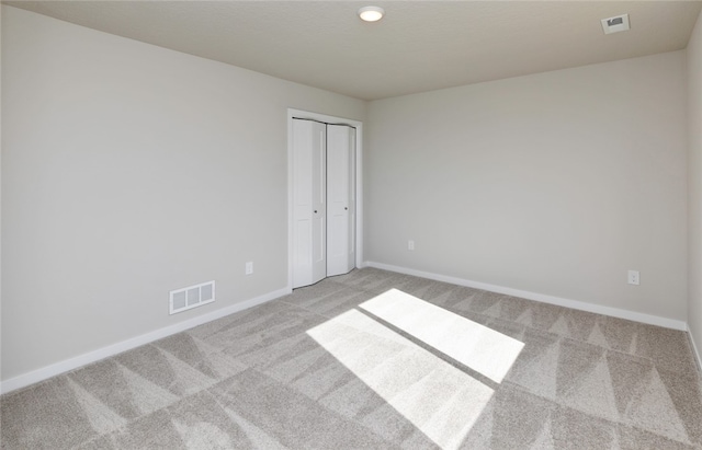 spare room featuring light colored carpet