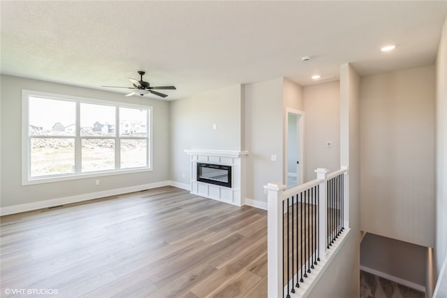 unfurnished living room with light wood-type flooring and ceiling fan