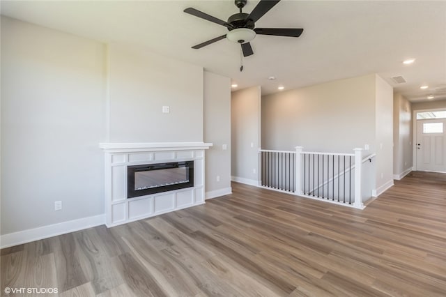 unfurnished living room featuring light hardwood / wood-style floors and ceiling fan