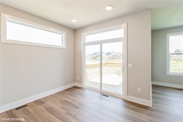 entryway featuring light hardwood / wood-style floors and a textured ceiling