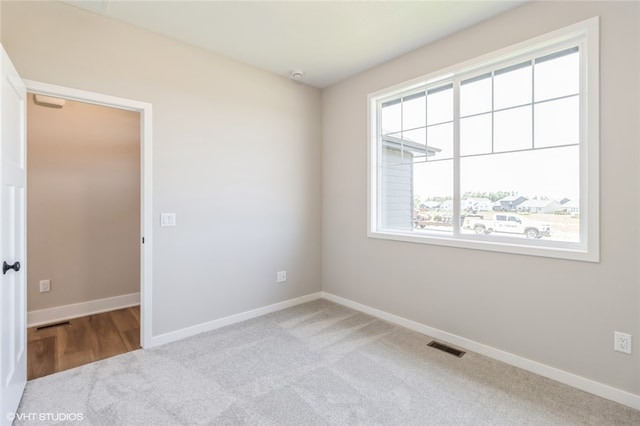 spare room featuring light carpet