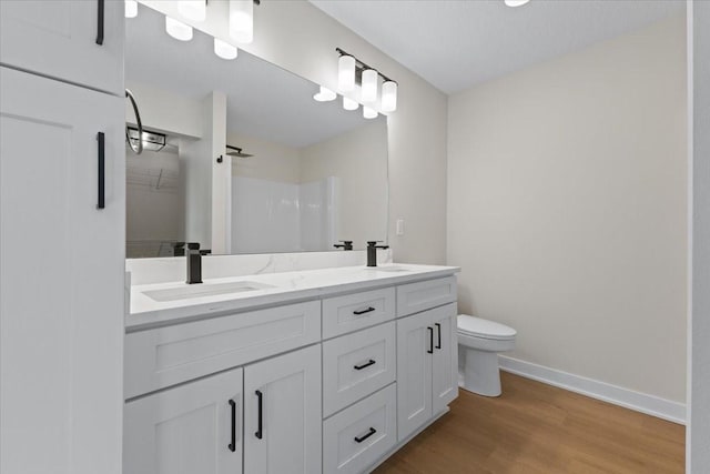 bathroom with vanity, hardwood / wood-style floors, toilet, and a shower