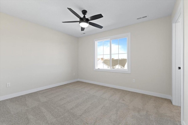 spare room featuring light carpet and ceiling fan