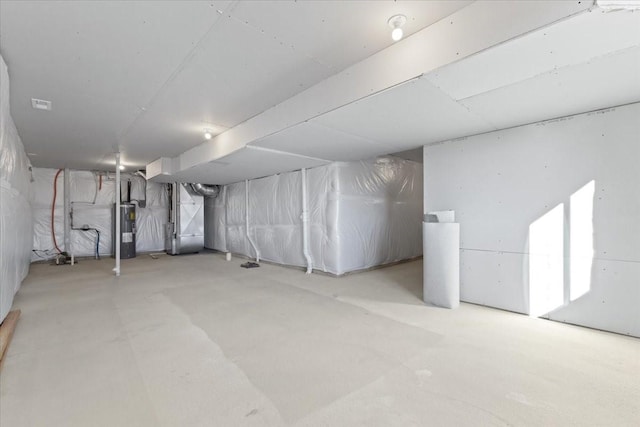 basement featuring electric water heater and heating unit