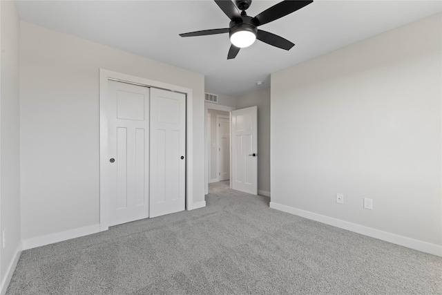 unfurnished bedroom featuring light carpet, ceiling fan, and a closet