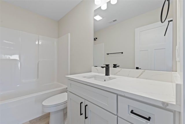 full bathroom with vanity, hardwood / wood-style flooring, bathing tub / shower combination, and toilet