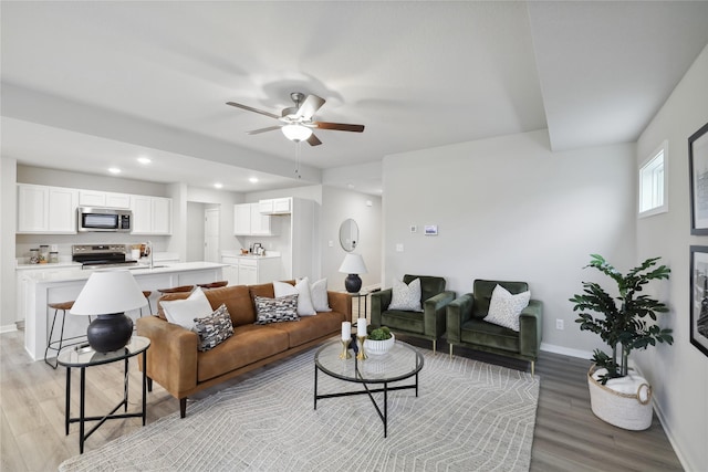 living room featuring light hardwood / wood-style floors and ceiling fan