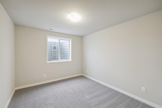 empty room with carpet flooring and a textured ceiling