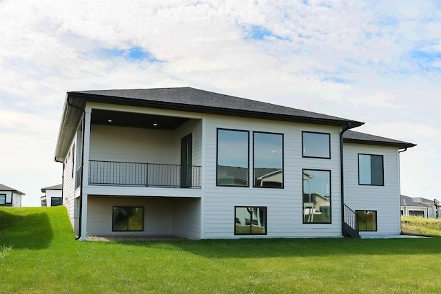 back of property featuring a balcony and a yard