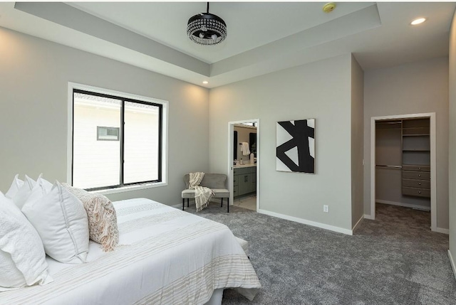 carpeted bedroom featuring a closet, a spacious closet, ensuite bath, and a raised ceiling