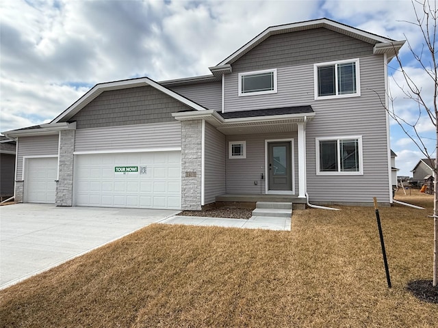 traditional-style home with a garage, a front yard, and driveway