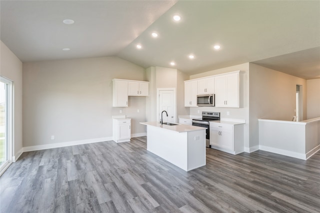 kitchen featuring a center island with sink, lofted ceiling, appliances with stainless steel finishes, and white cabinets