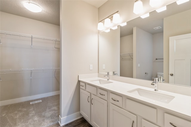 bathroom with vanity, a textured ceiling, and toilet