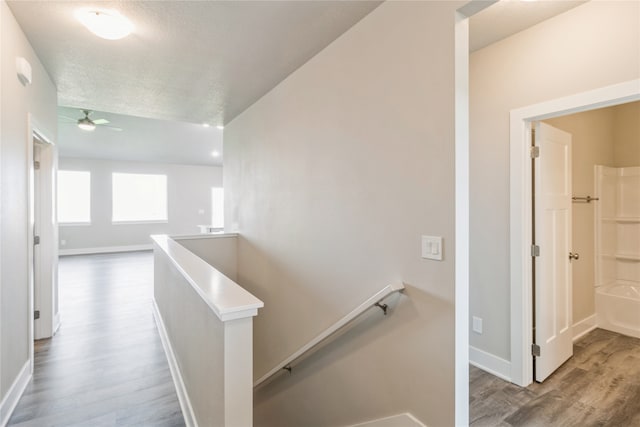 corridor featuring a textured ceiling and hardwood / wood-style flooring