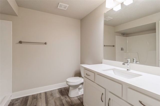 bathroom featuring vanity, toilet, hardwood / wood-style flooring, and a shower