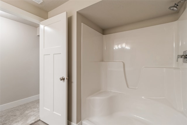 bathroom featuring a shower and a textured ceiling