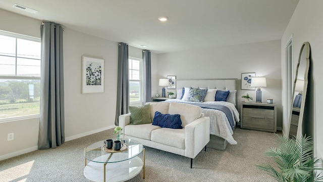 bedroom with visible vents, baseboards, and light carpet