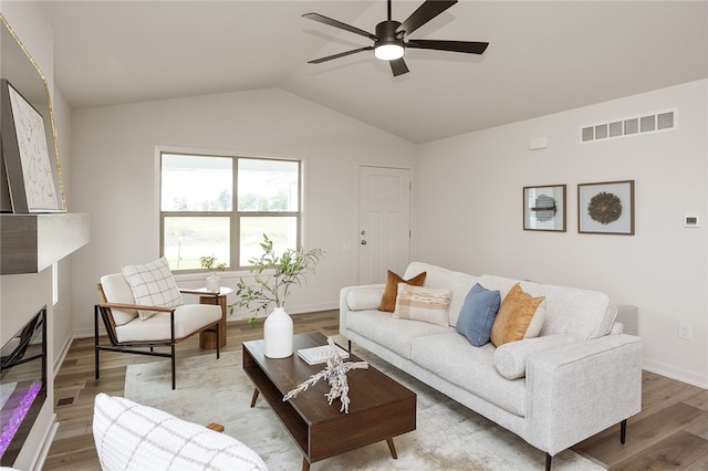 living room with ceiling fan, lofted ceiling, and hardwood / wood-style flooring