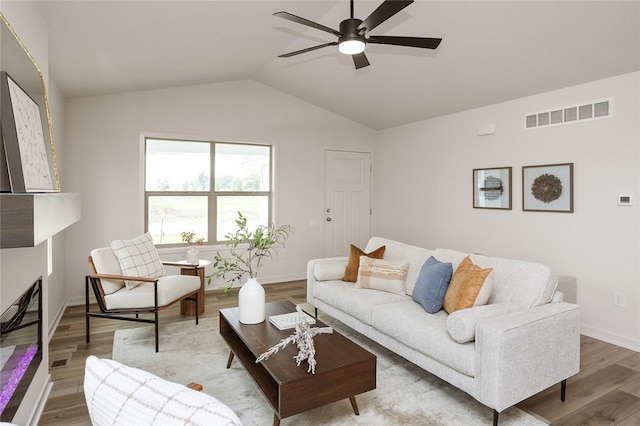 living room with hardwood / wood-style floors, vaulted ceiling, and ceiling fan