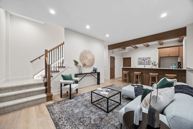 living room with vaulted ceiling with beams, light wood-type flooring, and bar