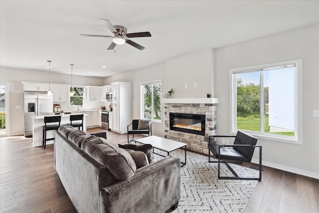 living room with a fireplace, hardwood / wood-style floors, and ceiling fan