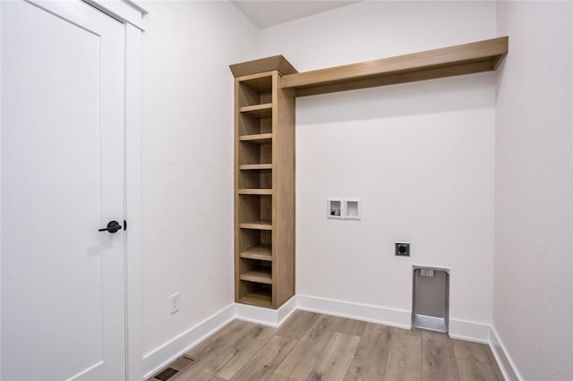 washroom featuring hookup for an electric dryer, light hardwood / wood-style floors, and hookup for a washing machine