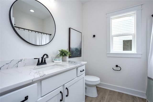 bathroom with vanity, toilet, and wood-type flooring