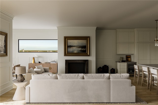 living room featuring crown molding, a fireplace, light hardwood / wood-style floors, and beverage cooler