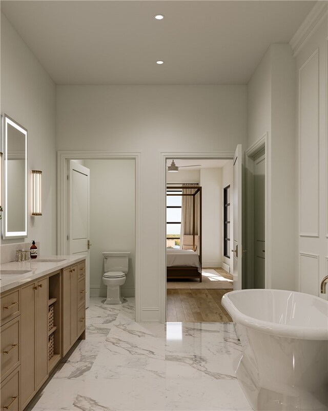 bathroom with vanity, hardwood / wood-style flooring, a bathing tub, and toilet