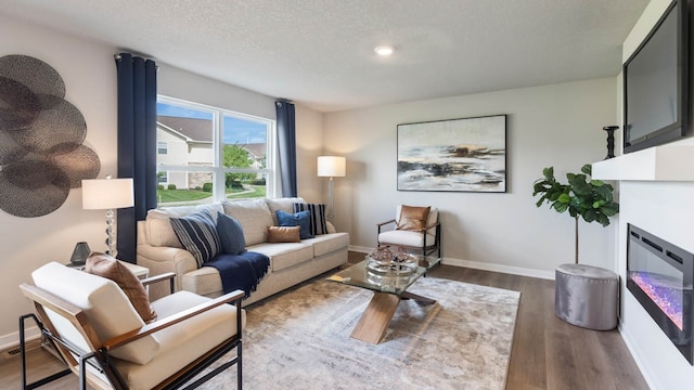 living room with a textured ceiling and hardwood / wood-style floors