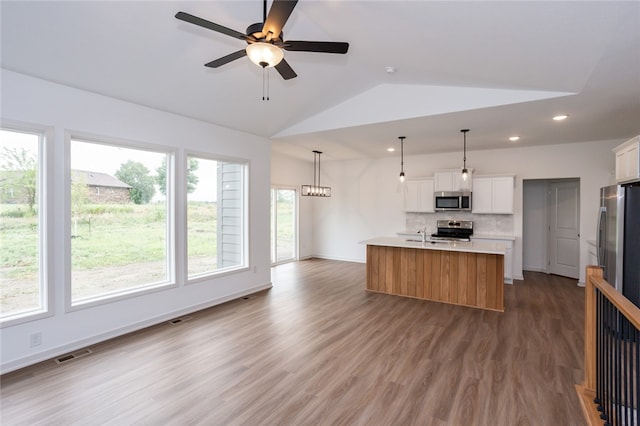 kitchen featuring a wealth of natural light, a center island with sink, white cabinets, and appliances with stainless steel finishes