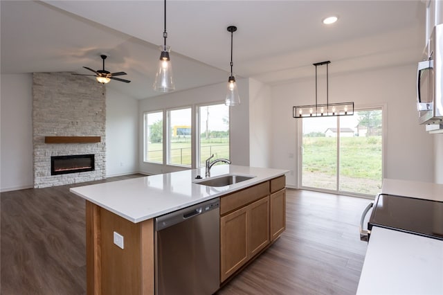 kitchen with appliances with stainless steel finishes, lofted ceiling, a kitchen island with sink, and a healthy amount of sunlight