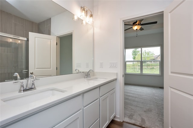 bathroom with ceiling fan, a shower with shower door, and vanity