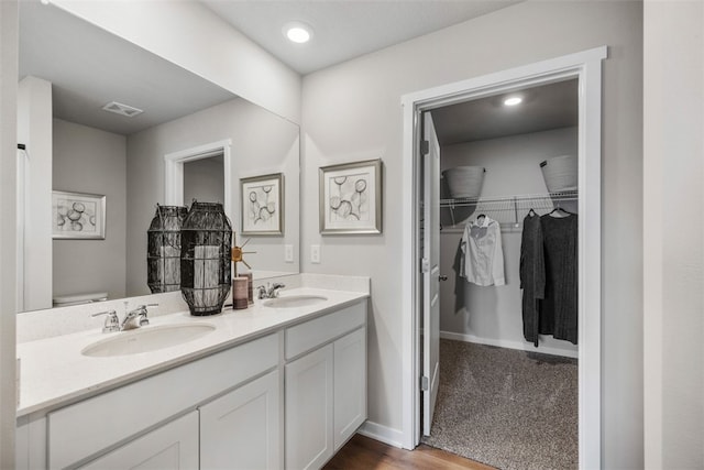 bathroom with vanity, toilet, and hardwood / wood-style flooring