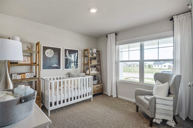 carpeted bedroom featuring a nursery area