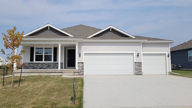 view of front of home with a porch, a garage, and a front lawn