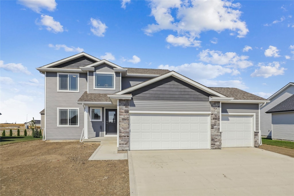 3610 NW 27th St, Ankeny, IA 50023 - view of front of property featuring concrete driveway, a garage, stone siding, and roof with shingles