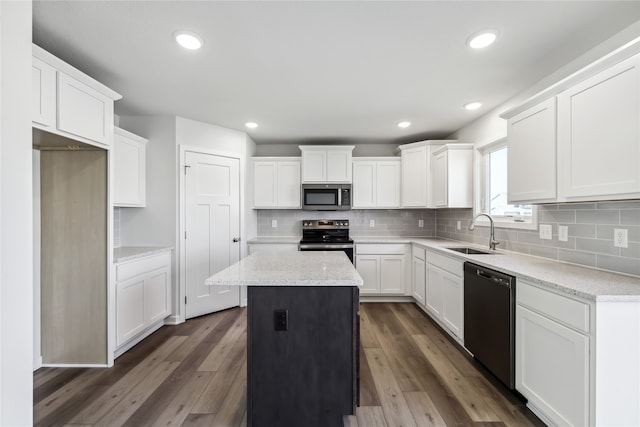 kitchen featuring white cabinets, appliances with stainless steel finishes, a kitchen island, and dark hardwood / wood-style flooring