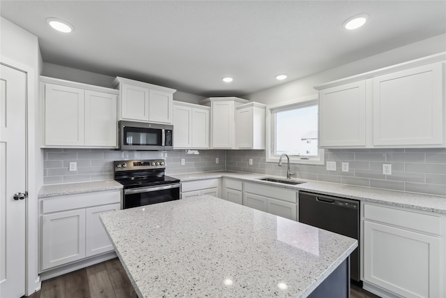 kitchen with dark wood-type flooring, sink, white cabinets, stainless steel appliances, and light stone countertops